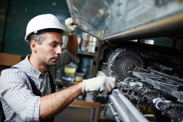 man doing industrial machinery repair 600x400